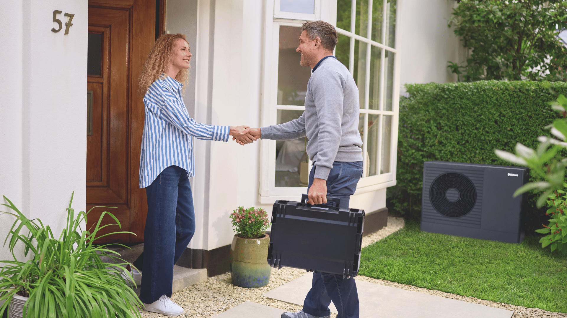 woman and installer shaking hands outside.