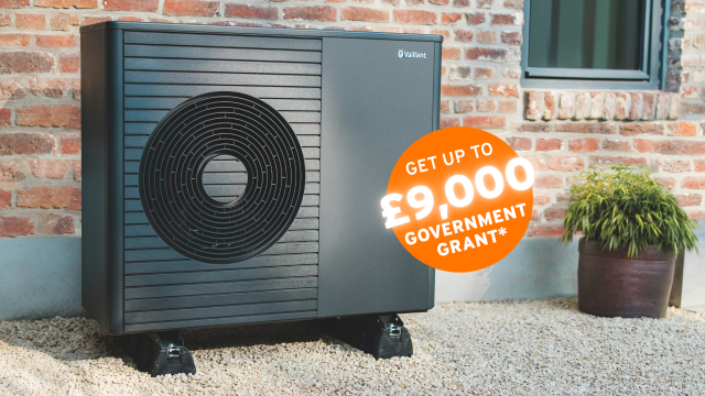 The Vaillant hare standing behind an aroTHERM plus heat pump with an orange circle sticker saying 'Get up to £9,000 government grant'