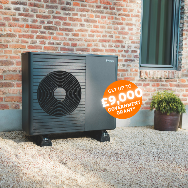 The Vaillant hare standing behind an aroTHERM plus heat pump with an orange circle sticker saying 'Get up to £9,000 government grant'