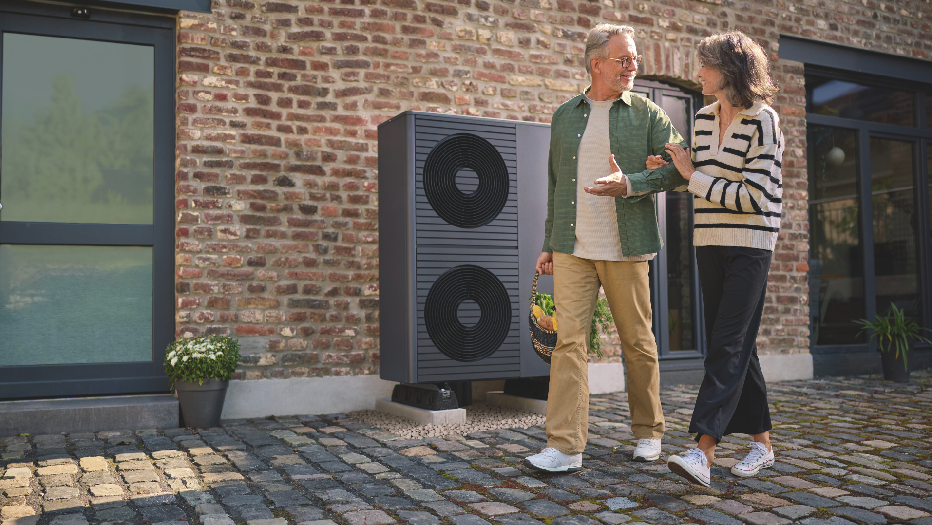 double fan aroTHERM plus with a couple walking in front of the heat pump.