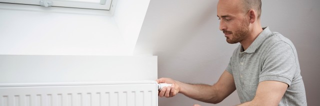 man holding onto the side of a radiator