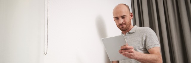 installer looking at a tablet whilst touching a radiator