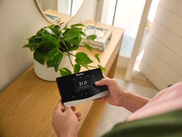 Person holding a Vaillant heating control