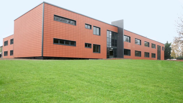 a copper building with grass infront