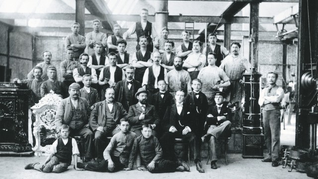 black and white image of a large group of men in a factory