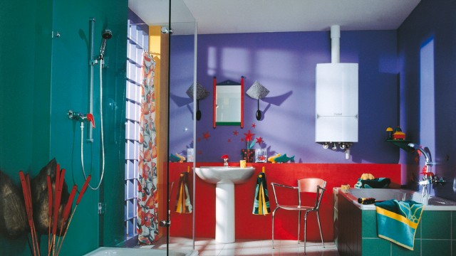 a green, purple and red bathroom with a wall hung white boiler on the wall