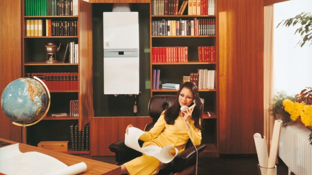 a woman sat on a leather chair on the phone with a boiler in the background and a globe to the left