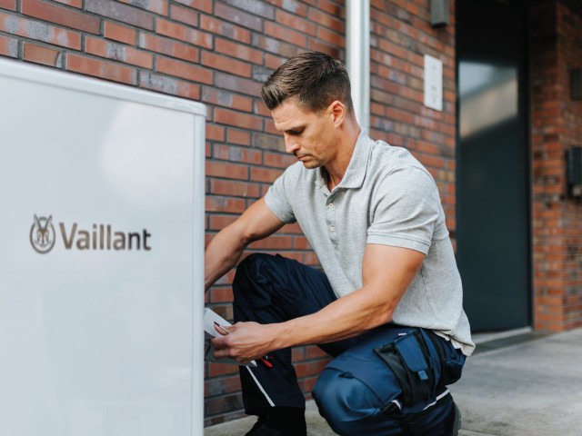 Vaillant installer putting the top panel of a heat pump on.