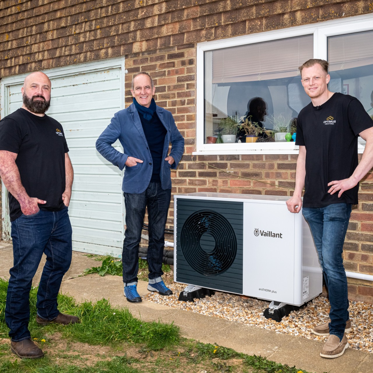 installers and kevin McCloud standing next to an aroTHERM plus heat pump.