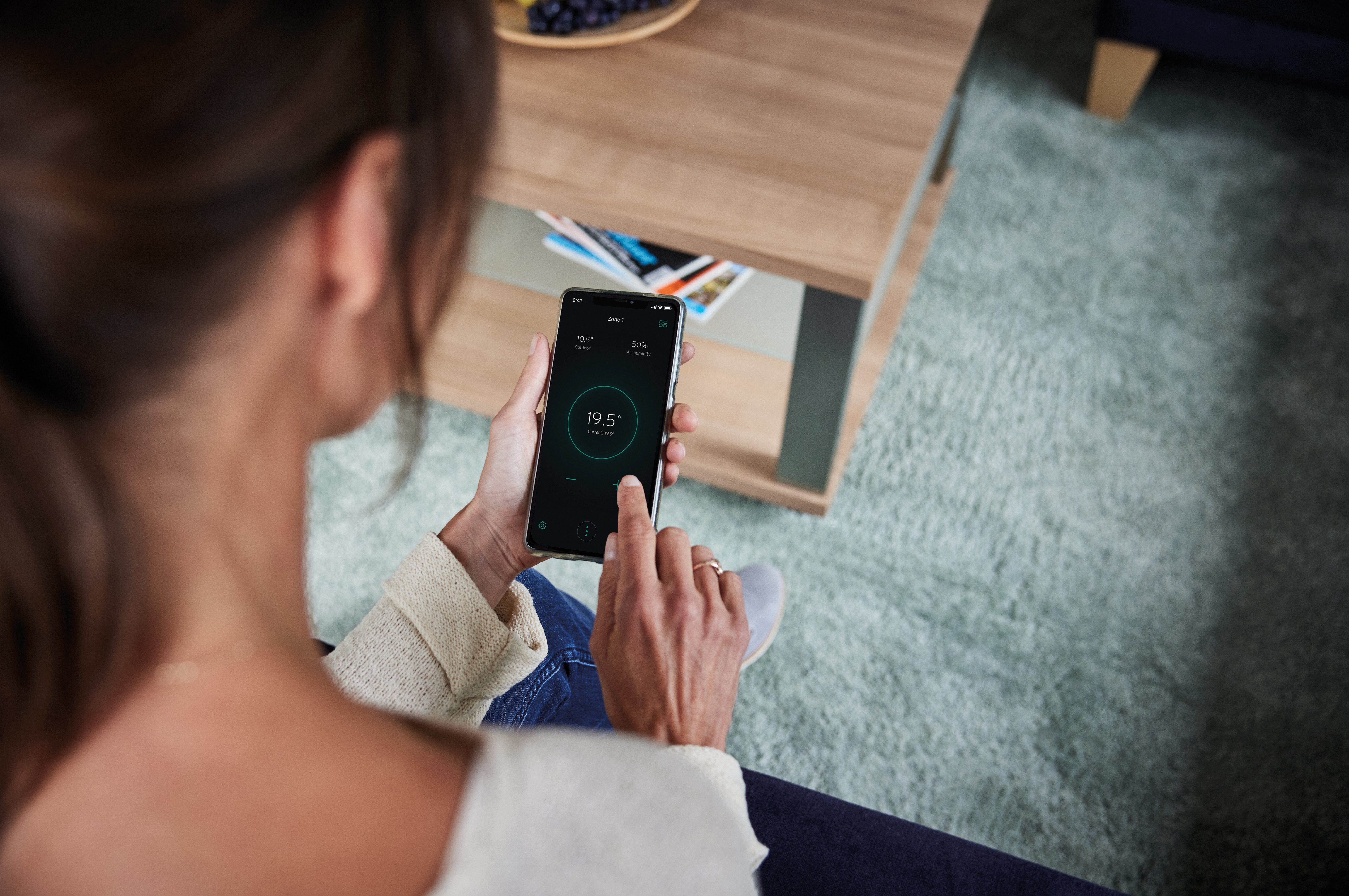 Person regulating the room temperature via Smartphone