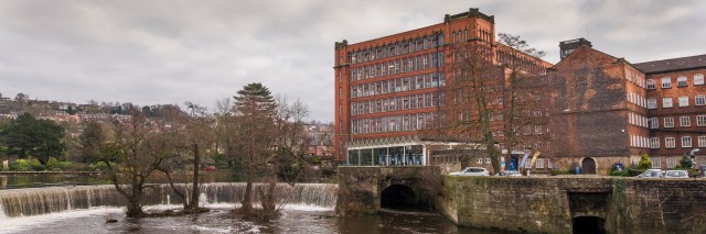Belper red brick mill and river with a water fall