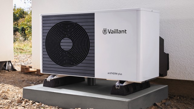 A house featuring a swimming pool and a large heat pump unit in a sunny outdoor setting.