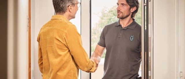 Two men shaking hands in a doorway