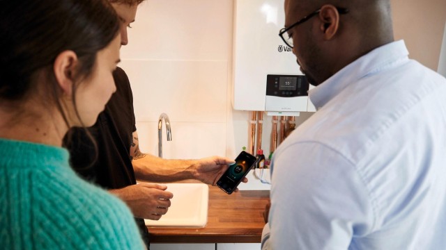 an installer holding his phone showing two people
