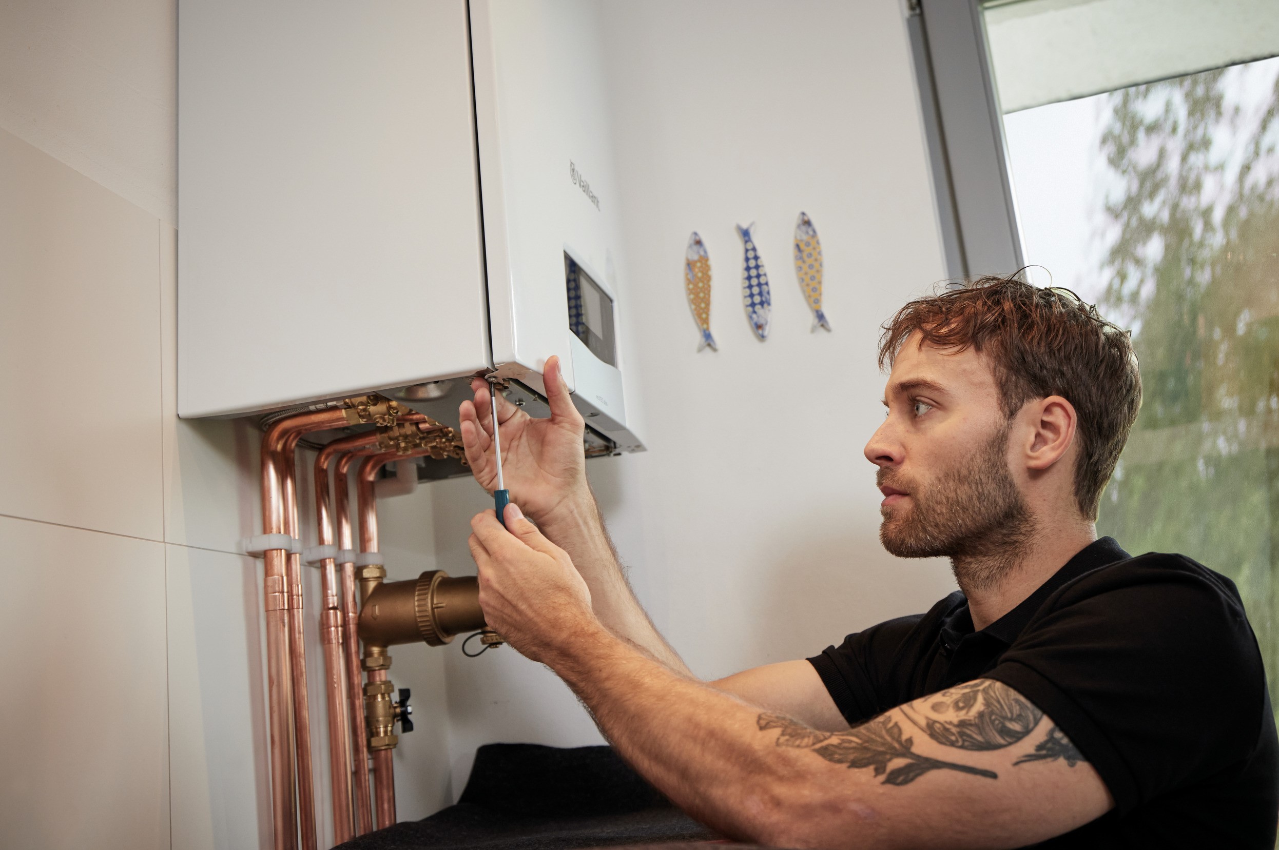 installer carrying out work underneath a boiler