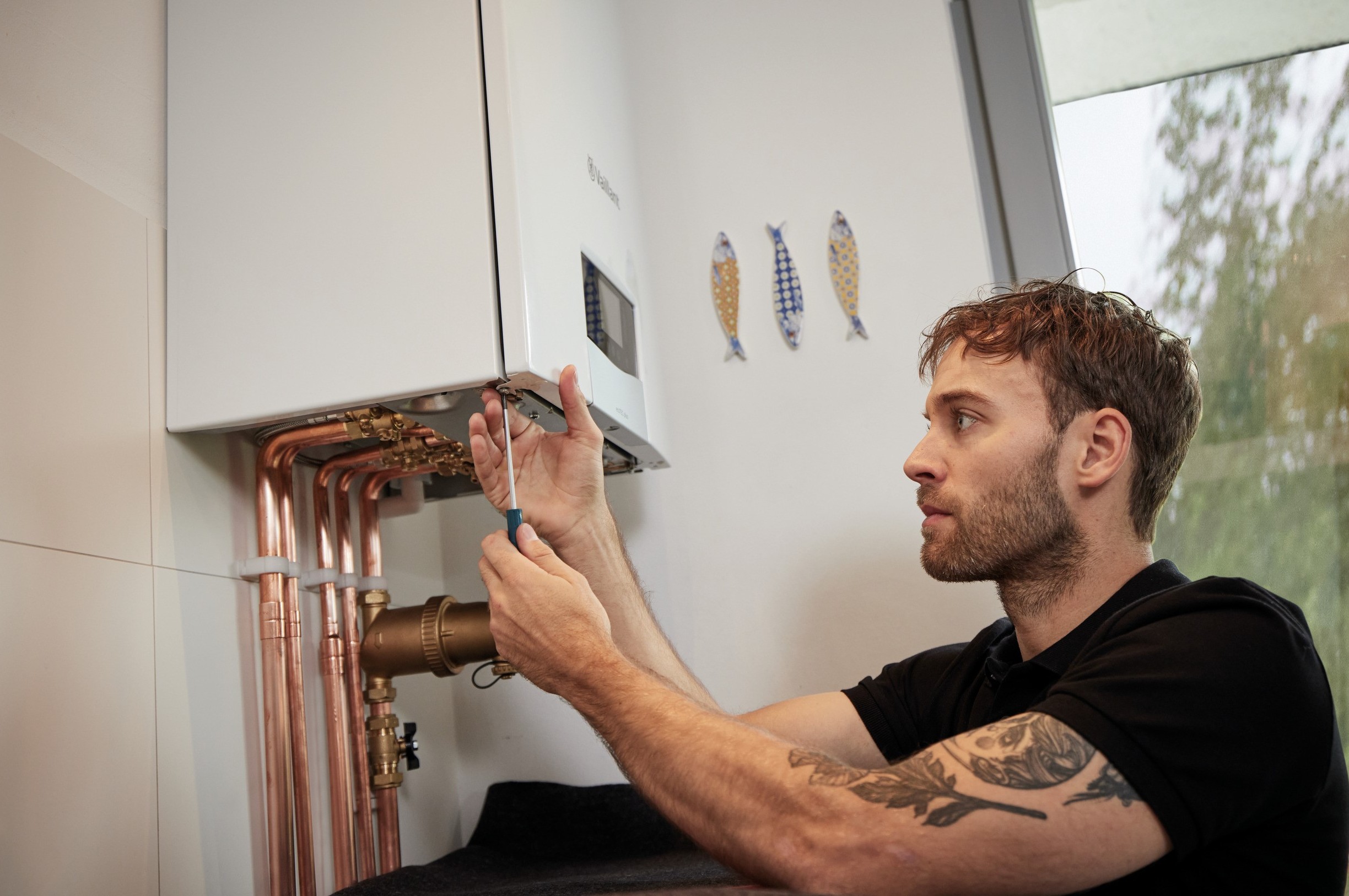 installer carrying out work underneath a boiler