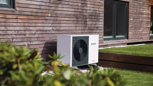 A Vaillant installer putting the top panel of a heat pump unit. 