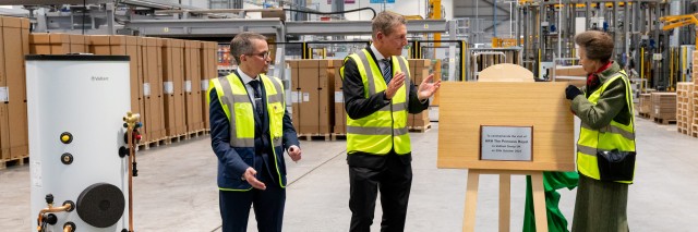 Princess Anne with Henrik Hansen and Joe Dunn standing next to a plaque and a uniSTOR cylinder