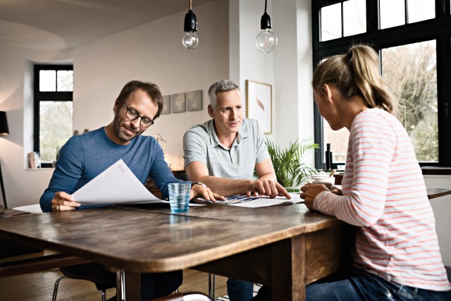 three people talking around a table