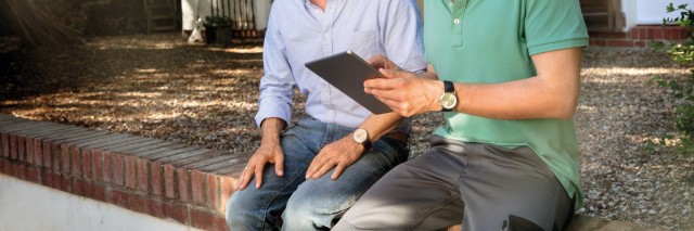 two people sat on a wall talking