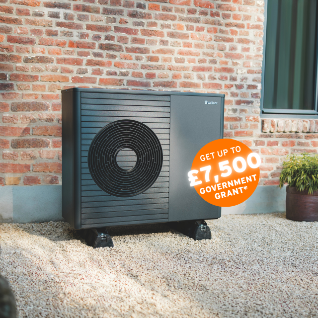 The Vaillant hare standing behind an aroTHERM plus heat pump with an orange circle sticker saying 'Get up to £7,500 government grant'