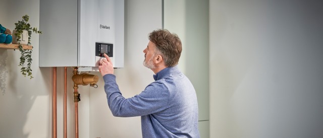 Man looking at this display screen on a Vaillant gas boiler.