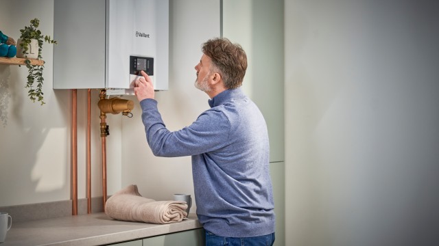 a homeowner looking at the display on a Vaillant gas boiler