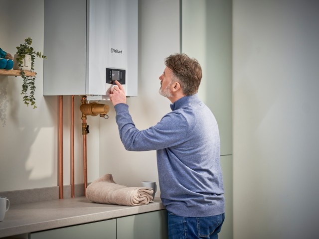 Man looking at this display screen on a Vaillant gas boiler.