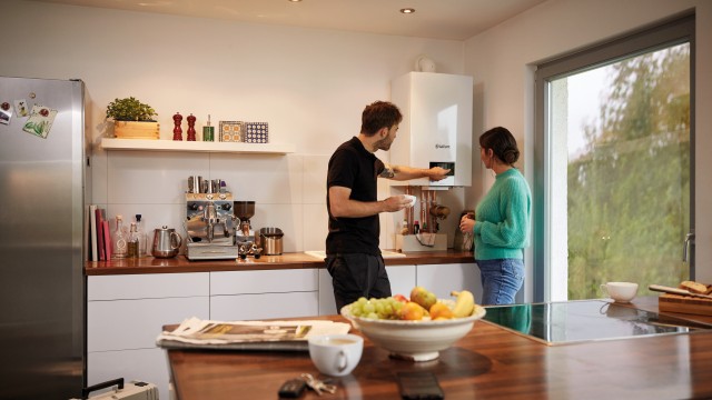 installer and woman in the kitchen looking at the boiler