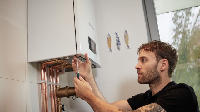 installer working underneath a boiler