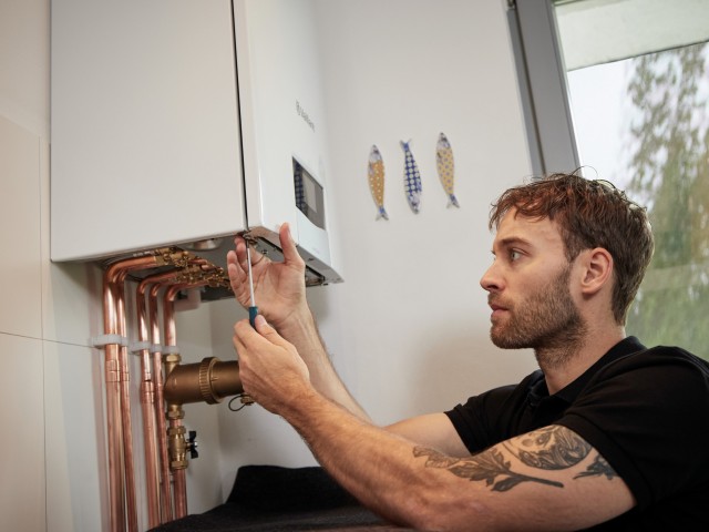 installer carrying out work underneath a boiler