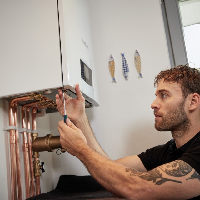 man doing work under a boiler