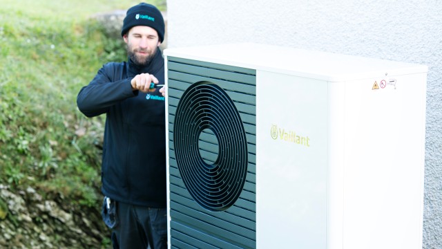 family sat on the grass with a heat pump 