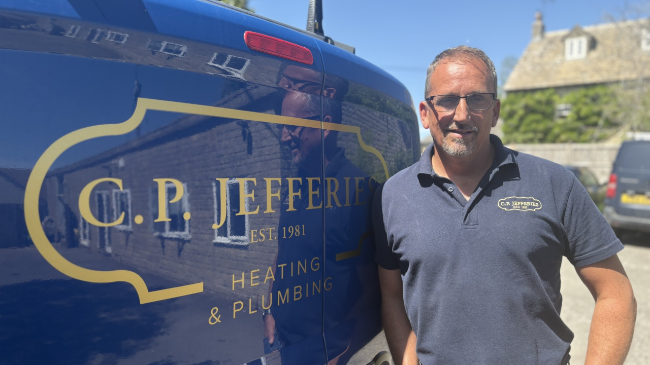 A man stands beside a van displaying the logo of C P Jeffery, showcasing the company's branding and presence