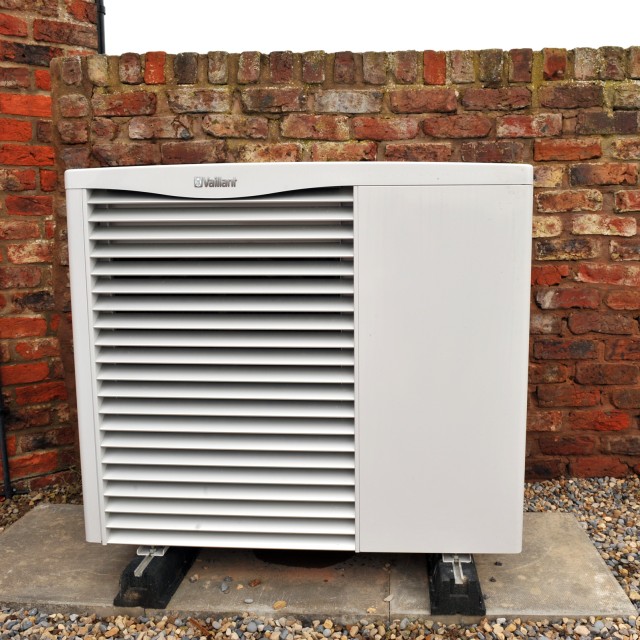 aroTHERM heat pump outside and in front of a brick wall