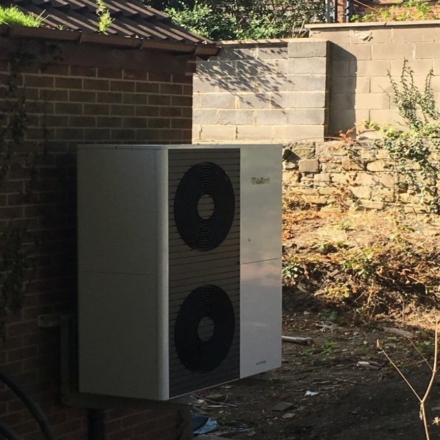 side angle of a 12kW heat pump outside 