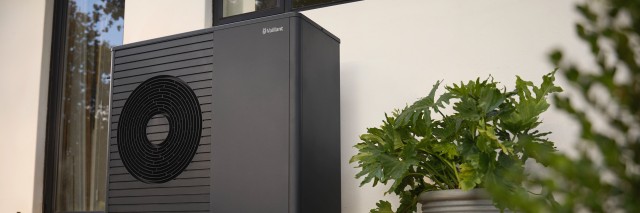 a heat pump outside a red house