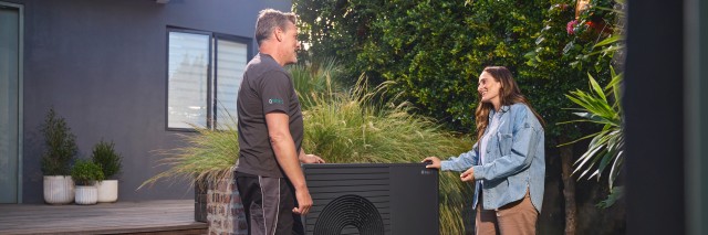 aroTHERM plus in a garden with a homeonwer and Vaillant installer talking 