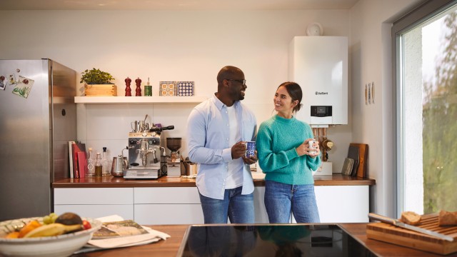 man and woman in the kitchen with a boiler in the background
