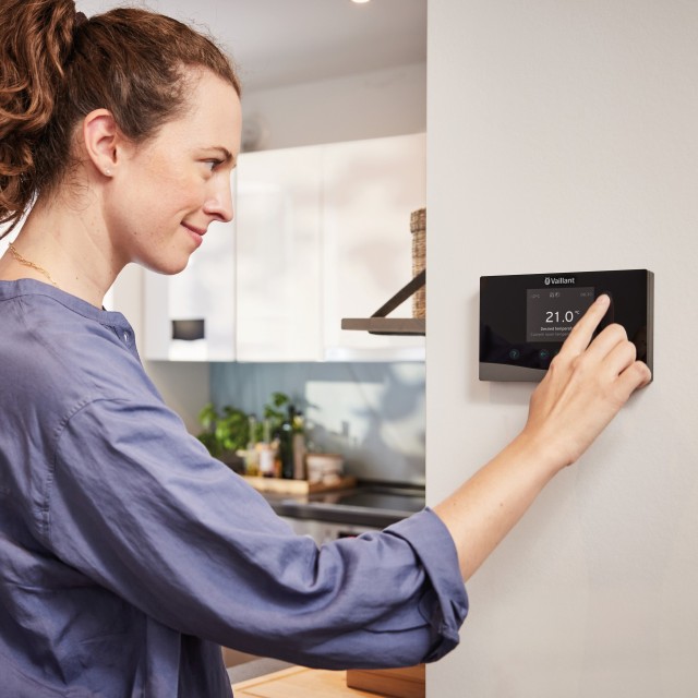woman turning down her thermostat