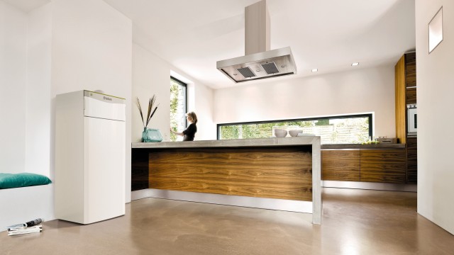 flexoTHERM heat pump in a kitchen with a lady at the sink