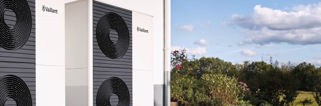 Side view of two 12kW aroTHERM plus heat pump. Grass and blue sky with clouds