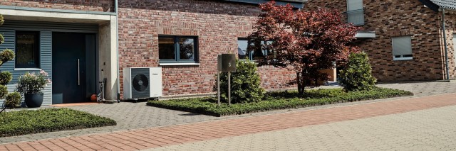 air source heat pump outside a large brick home