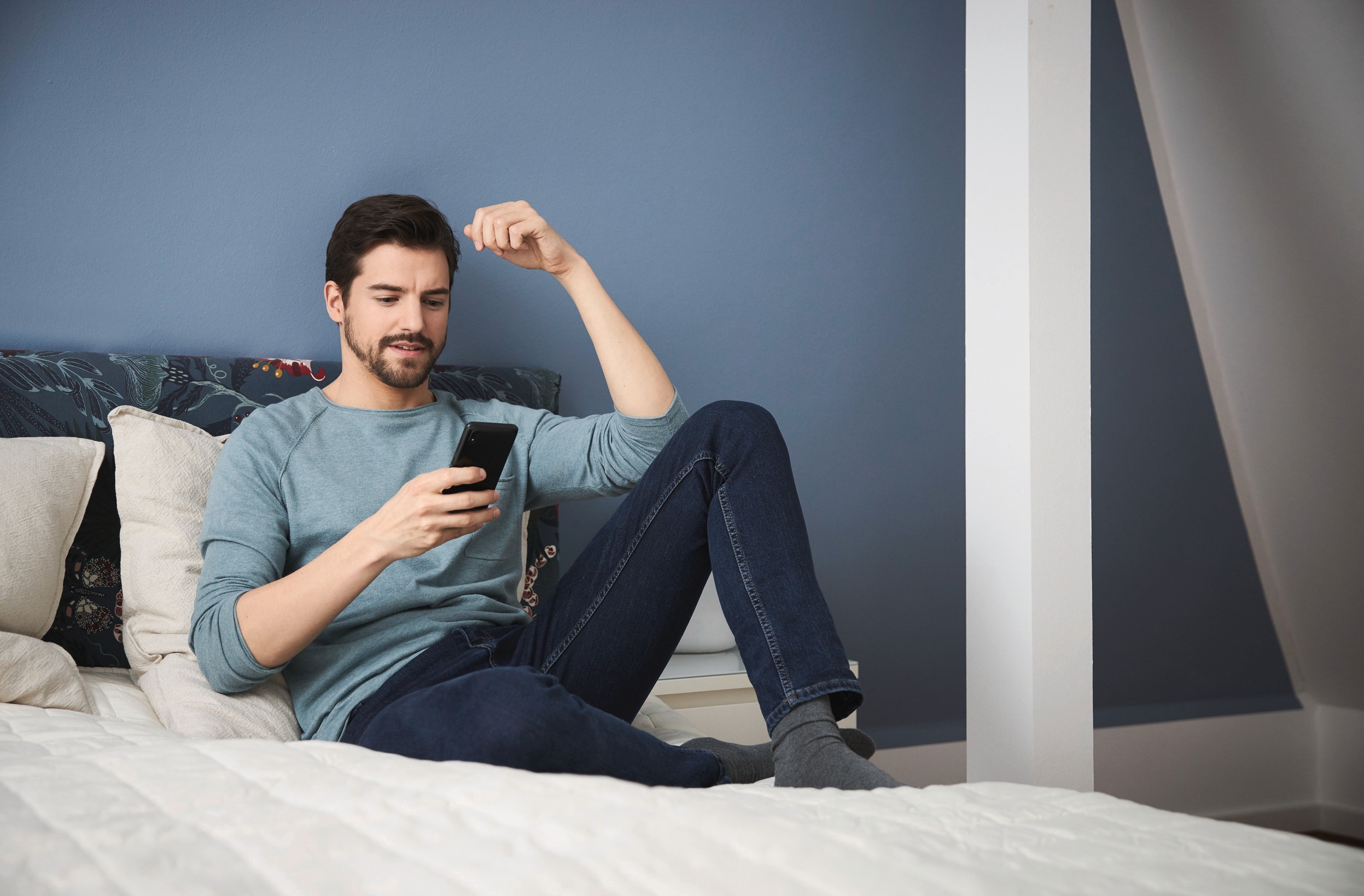 man sat down looking at his phone