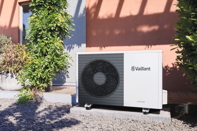 a heat pump in front of a brick wall