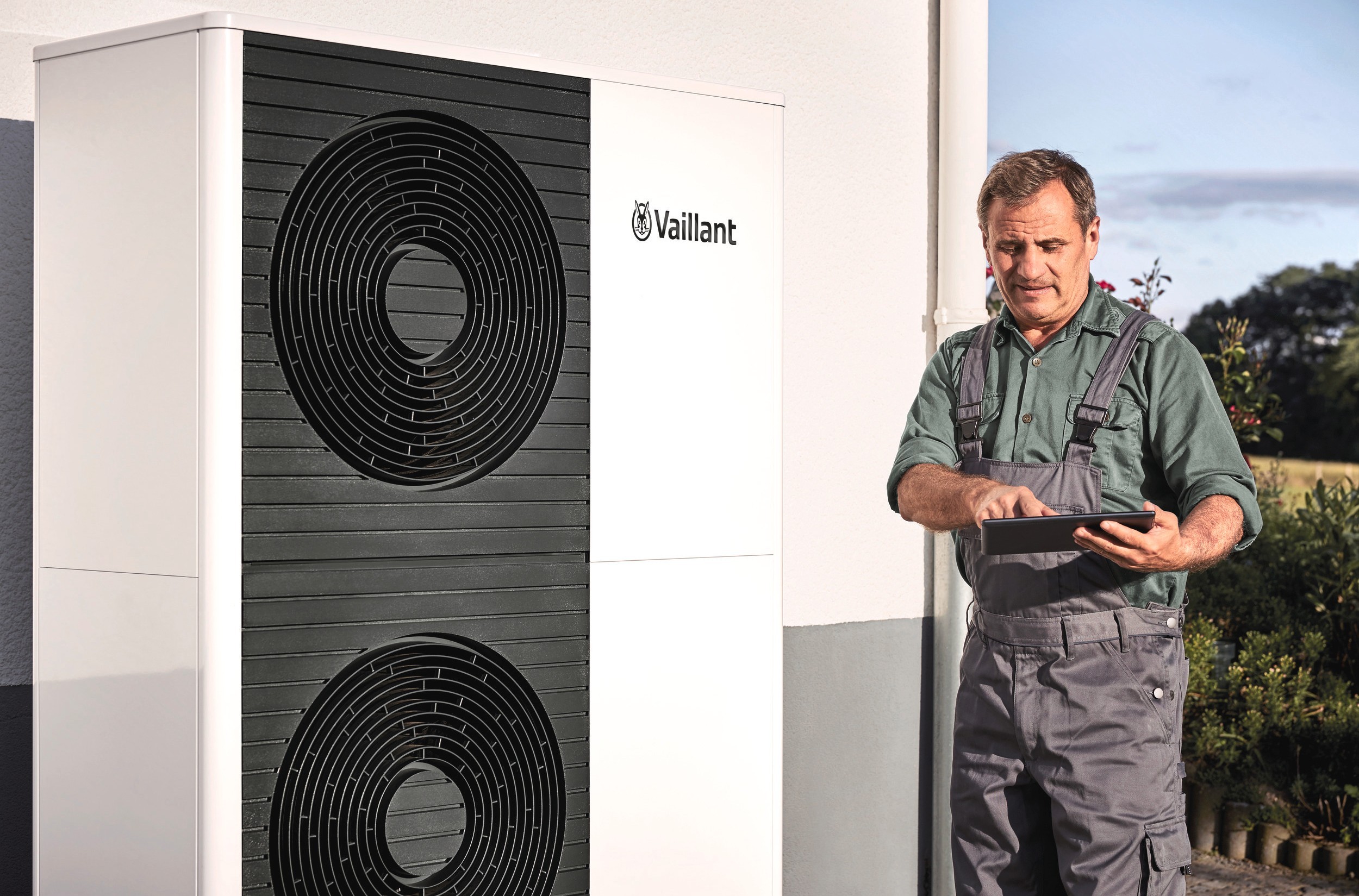 person looking at a screen standing next to a heat pump