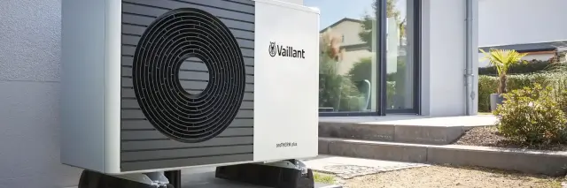 Heat pump outside of house with white cladding