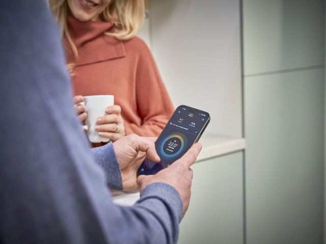 gas boiler on a kitchen wall and cylinder in a cupboard with other utility appliances. 