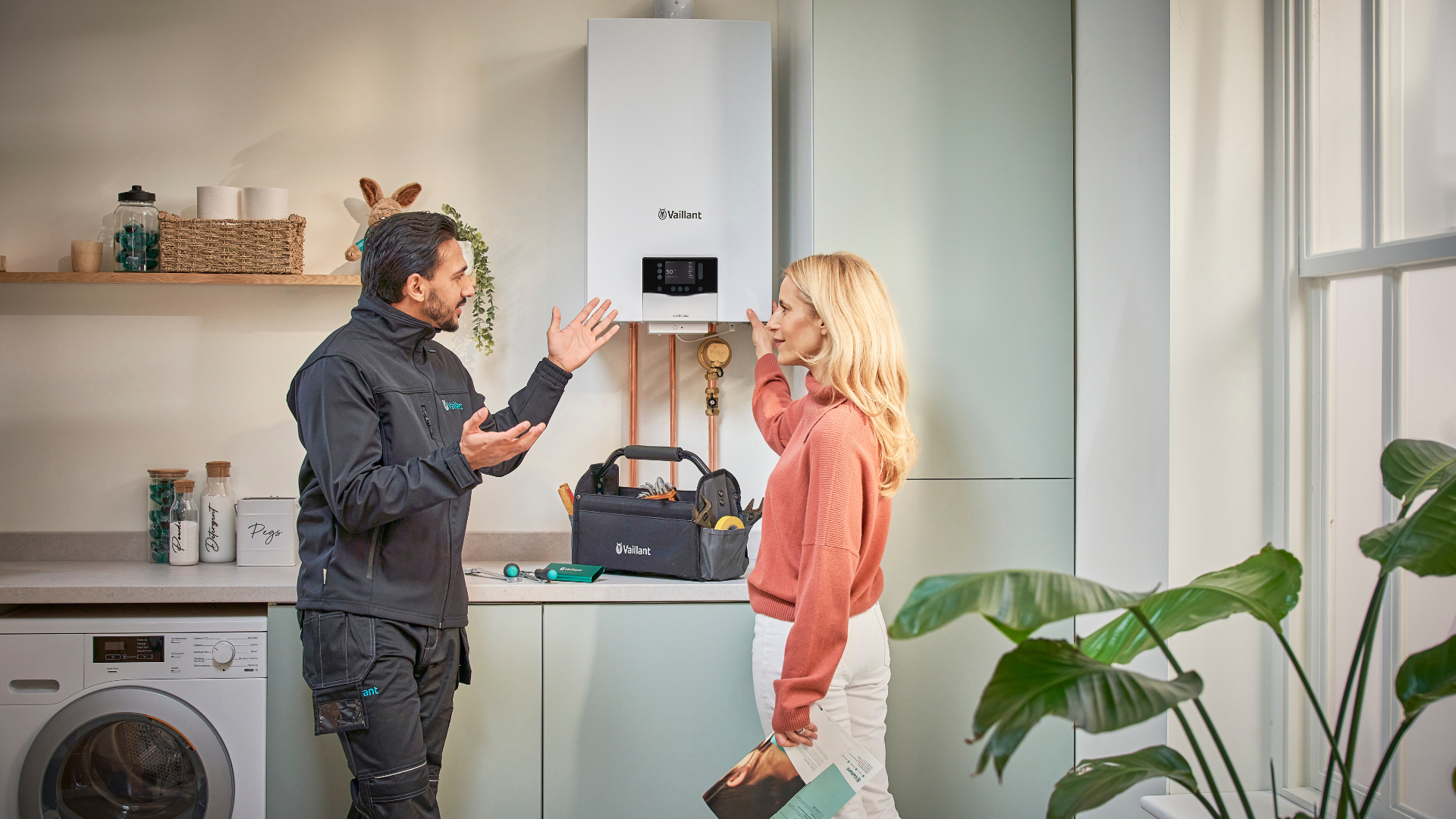 An installer speaking to a woman in the kitchen